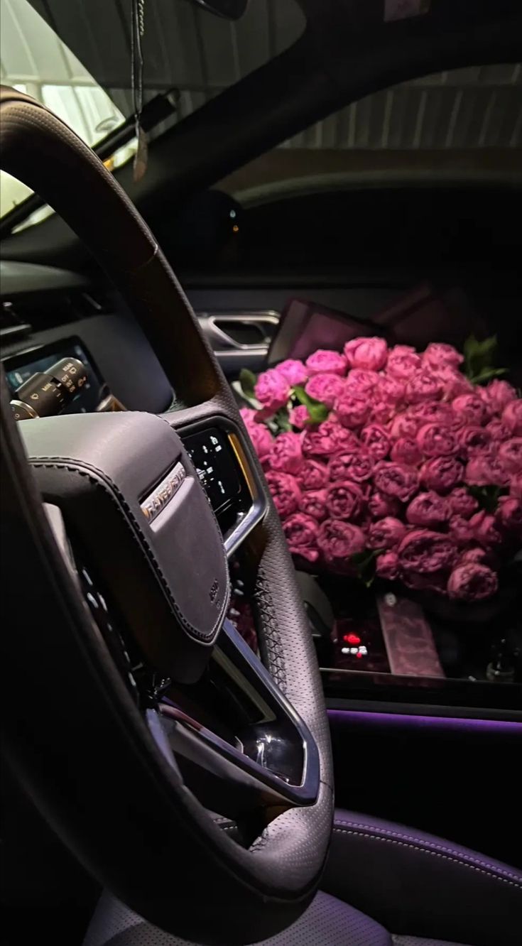 the interior of a car with pink flowers in the center and on the dash board