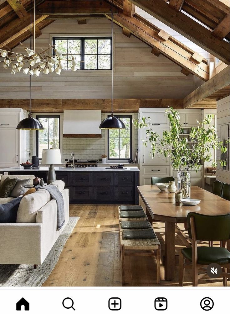 a living room filled with furniture next to a kitchen and dining room table on top of a hard wood floor