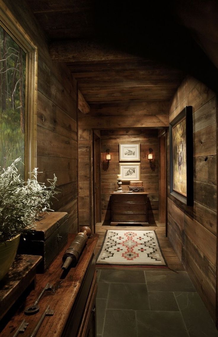 a long narrow hallway with wood paneling and plants on the floor in front of it