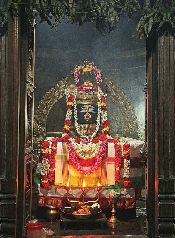 the statue is decorated with flowers and garlands