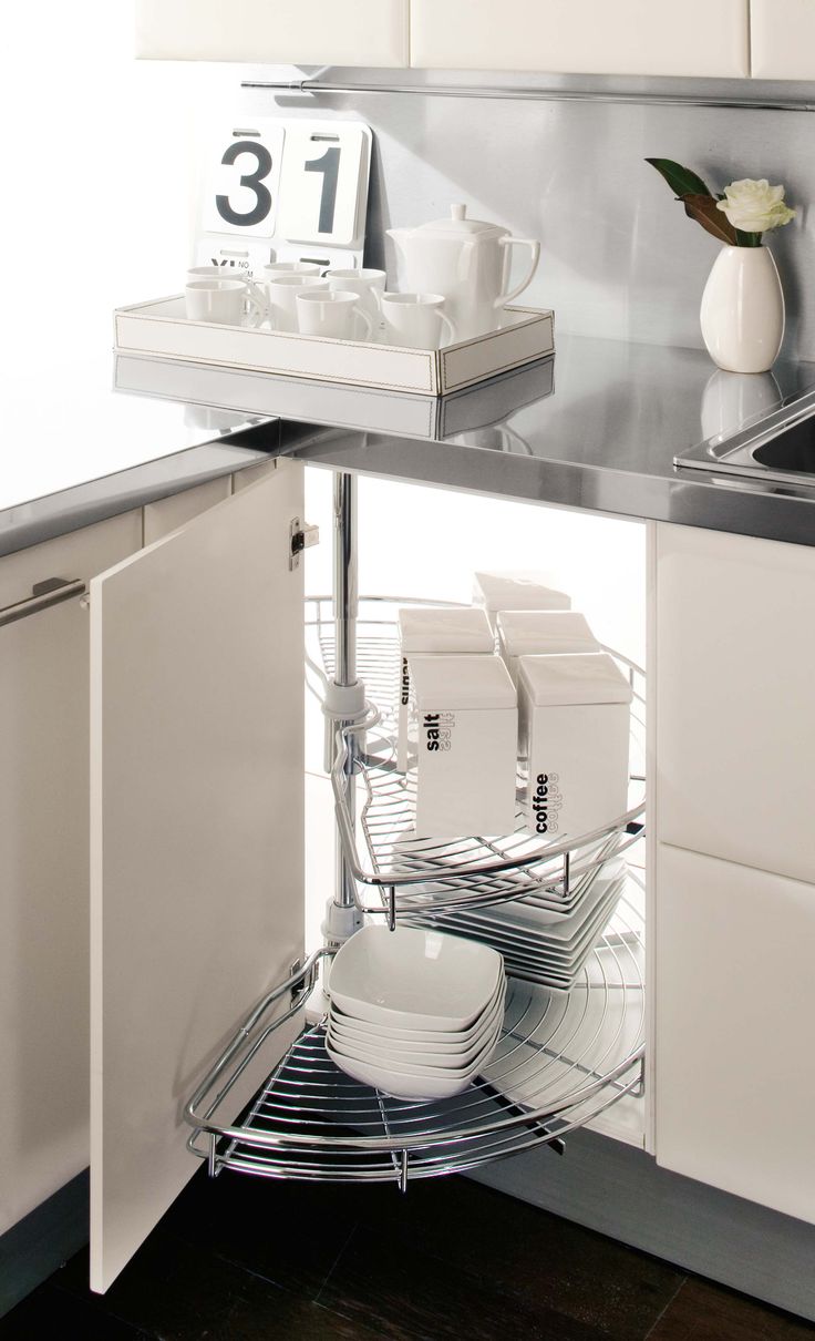 the corner of a kitchen with dishes and cups on it's shelf is shown