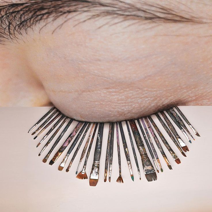 an eye with makeup brushes attached to it