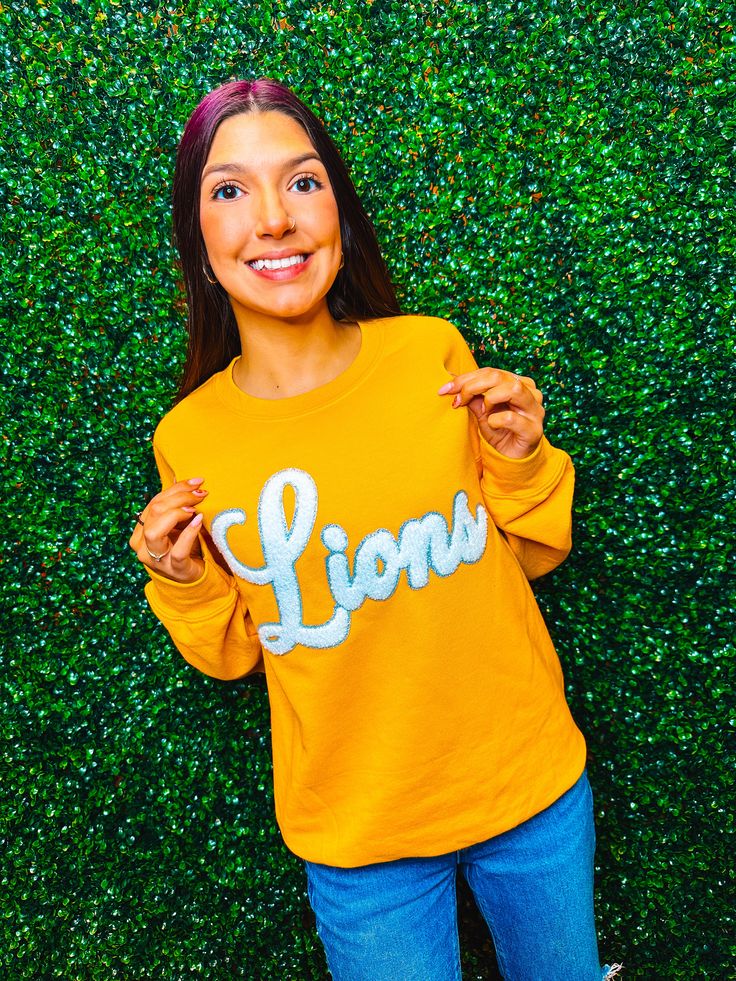 Show your school spirit with this cozy and stylish Lions Chenille Sweatshirt! Customize your sweatshirt color to match your team or school perfectly. Perfect for everyday wear, it’s comfortable, cute, and sure to make you stand out. Go Lions! Unisex sizing and fit Size: Adult Small - Adult 3XL There are many different shirt colors. If the variant you want is not in the dropdown but in the picture, specify it in the "notes" section at checkout. SPECIAL CARE - WASHING INSTRUCTIONS: Hand washing an Childrens Wreath Sweatshirts, Sequined Sweatshirt, Team Cap, Bag Patches, White Lion, Sequin Shirt, Sweatshirt Designs, School Spirit, Clothes Collection