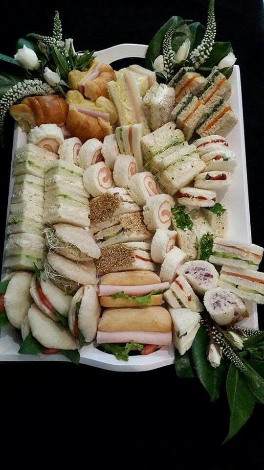 a platter filled with sandwiches and croissants