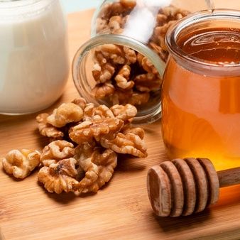 honey and walnuts on a wooden cutting board