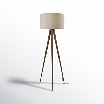 the floor lamp is made from wood and has a beige shade on it's base