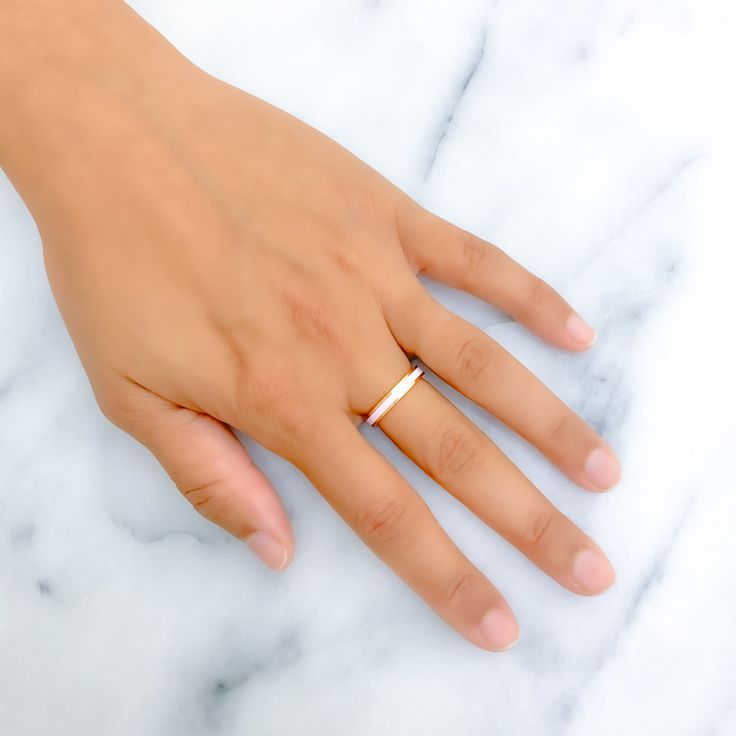 This 22k gold ring captivates with its glossy baby pink enamel finish, beautifully set against a backdrop of yellow gold. It weighs 4.4 grams and is sized at 7, perfectly combining playful charm with a hint of sophistication. Ideal for those who favor a delicate and feminine touch in their jewelry, this band is both eye-catching and elegant. The fixed size ensures the ring's pristine condition and form, making it a timeless choice for anyone looking to add a soft color accent to their collection