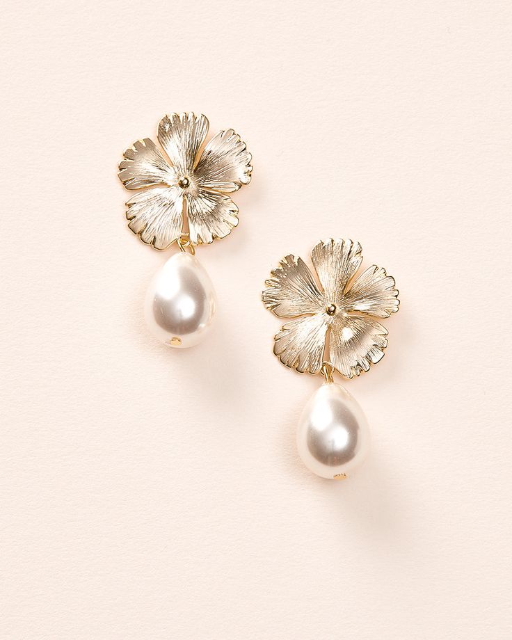 Bring a soft, feminine touch to your wedding day look with our Hayden Pearl Earrings. Each detailed metal flower is accented with an off white pearl drop that dangles effortlessly. Off white pearls Measures 1" x 1.5" long Hypoallergenic, lead-free & nickel-free Style #4456 Classic Flower Shaped Earrings For Wedding, Formal Dangle Flower Earrings With Pearl Drop, White Flower-shaped Earrings With Pearl Charm, Formal Pearl Drop Dangle Flower Earrings, Formal Pearl Drop Flower Dangle Earrings, Metal Jewelry With Flower Charm For Wedding, Formal Pearl Drop Flower Earrings, Formal Pearl White Flower Drop Earrings, Wedding Jewelry With Metal Flower Charm