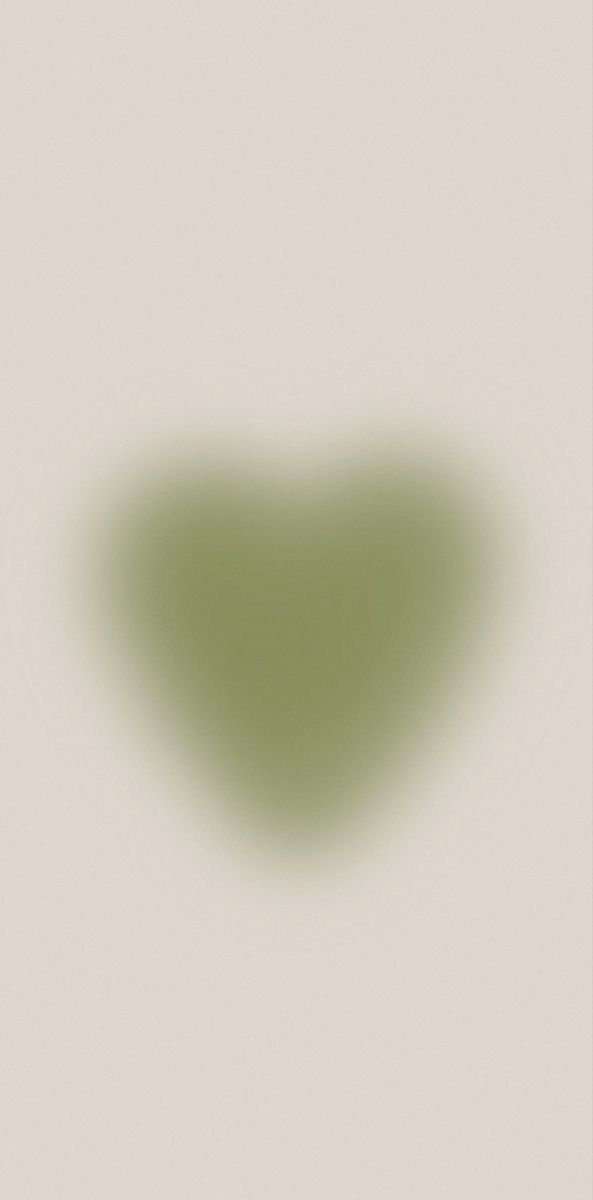 a blurry image of a heart shaped object on a white background with the light reflecting off it's surface