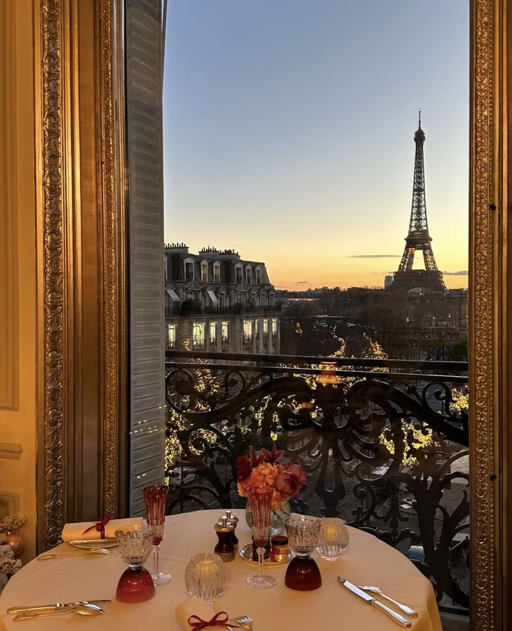 the table is set for dinner overlooking the eiffel tower