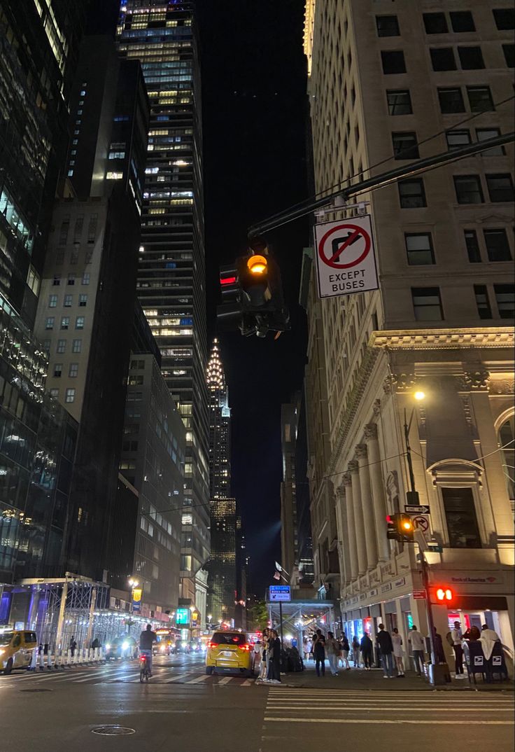 a city street at night with traffic lights and tall buildings