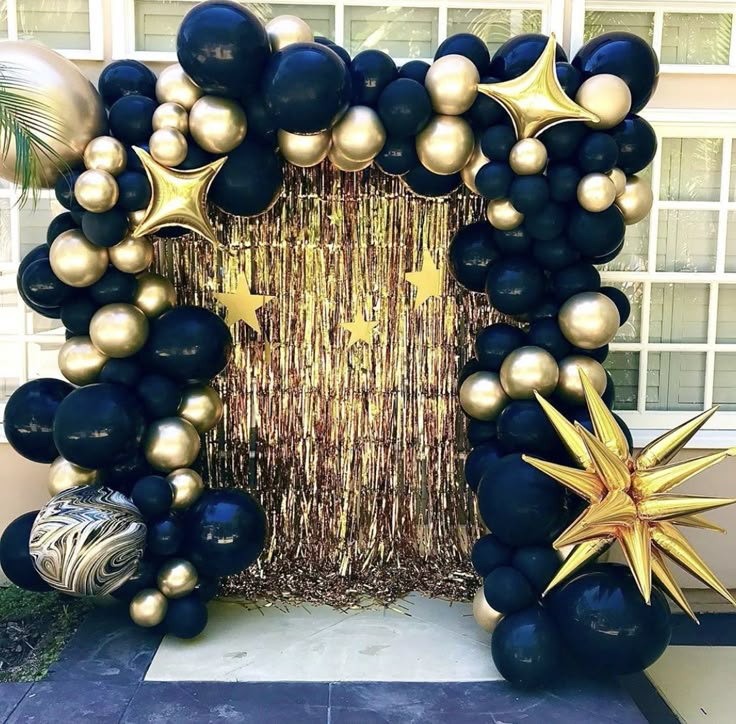 black and gold balloon arch with star decorations