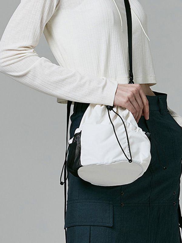 This is a casual and comfortable mini bucket bag that is made out of high quality polyester and nylon 100% fabric. With design detail of detachable cross strap and logo print on the back, it gives a trendy and casual mood.- Matte texture of nylon fabric- 3M elastic string and logo print on the back - Detachable cross strap Casual White Shoulder Bag For On-the-go, Casual White Nylon Shoulder Bag, White Nylon Bags With Zipper Closure, White Nylon Bag With Zipper Closure, White Sporty Crossbody Bag, Sporty White Crossbody Bags, White Nylon Bag For Everyday Use, Casual Bucket Bag With Zipper Closure, White Nylon Bags For Spring