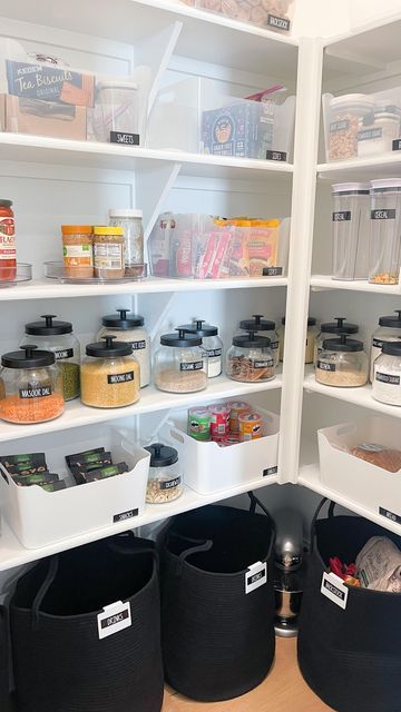 an organized pantry with bins and containers on the bottom shelf, full of food