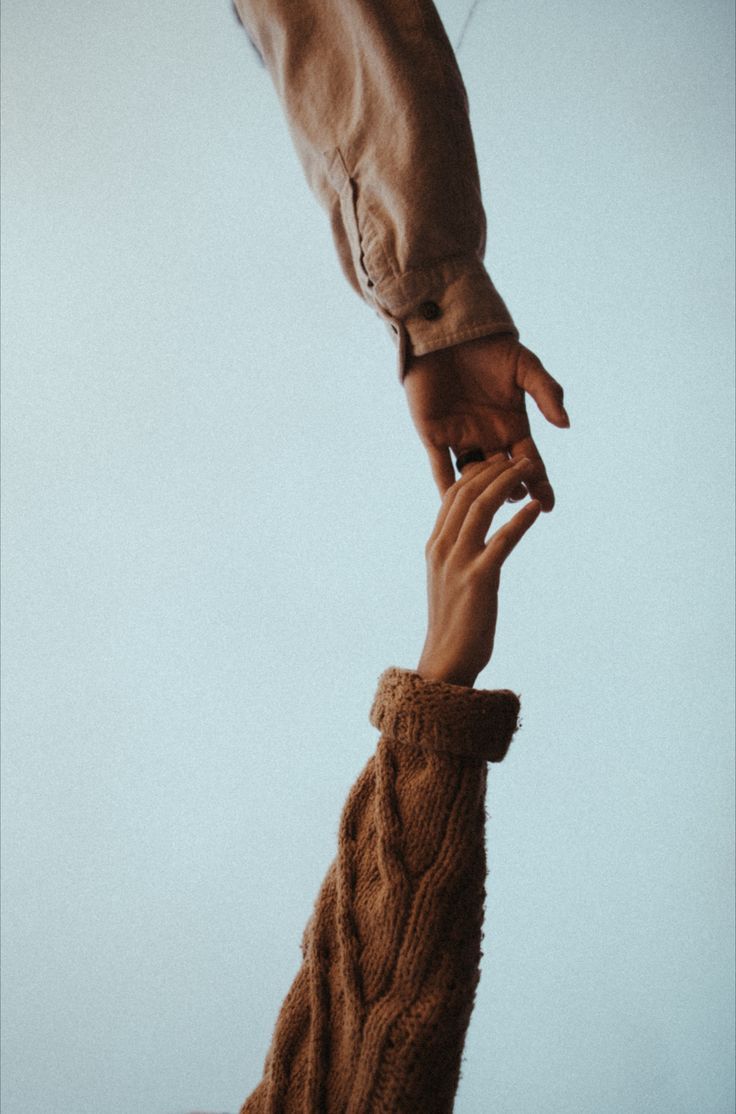 two people holding hands in the air