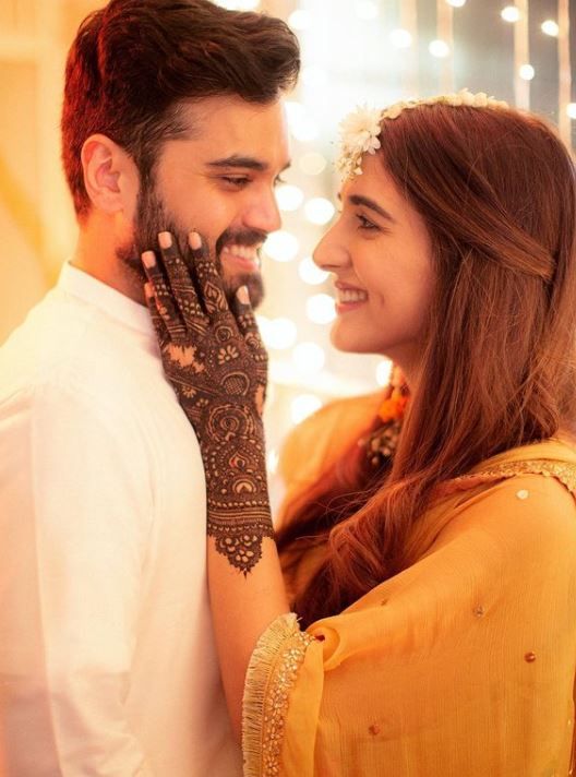 a man and woman with henna on their hands looking into each other's eyes