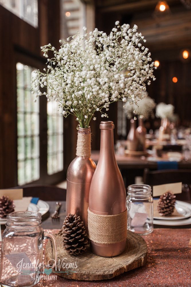 two vases filled with baby's breath sitting on top of a table