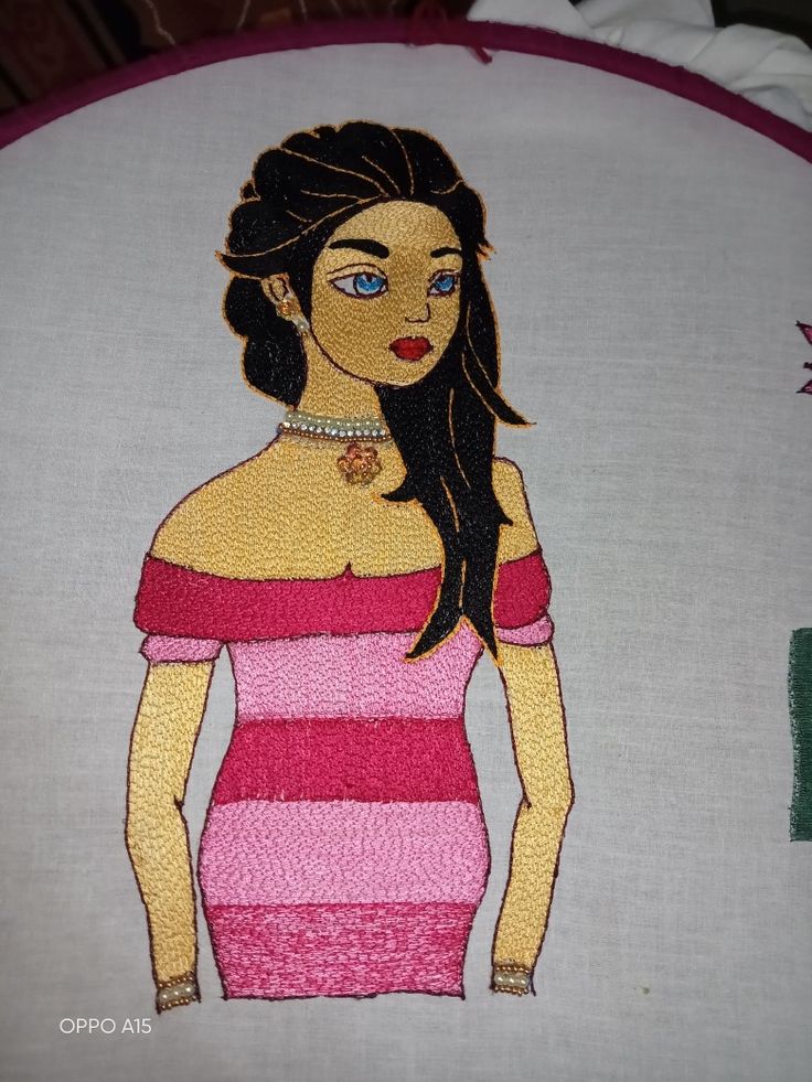 a woman in a pink and white striped dress is shown on a round embroidered pillow