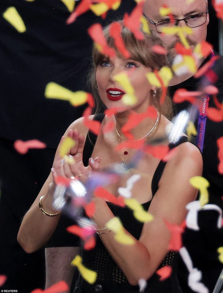 a woman standing next to a man in front of confetti