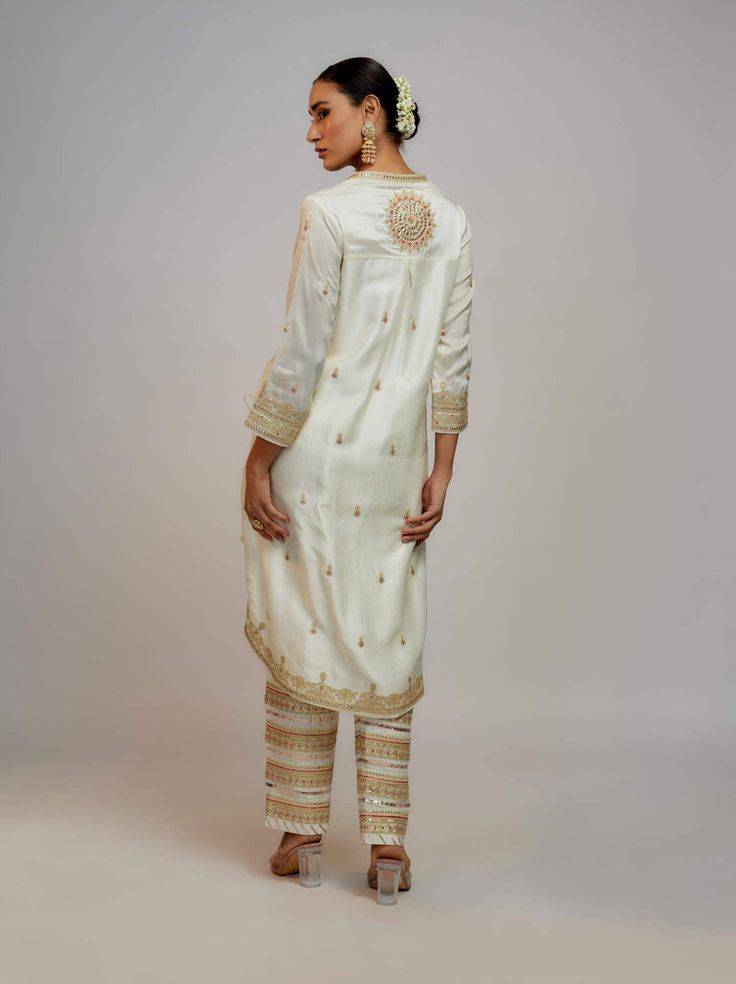 Editor's Note Elevate your style with a fusion of contemporary design and traditional elegance. This kurta, dupatta, and pant set is meticulously crafted with intricate detailing, a flattering pattern, and a perfect blend of modern and ethnic elements. It's a statement ensemble that effortlessly combines grace and modern flair. Cotton Silk Kurta With Dabka Work In Traditional Drape, Traditional Drape Kurta With Dabka Work In Cotton Silk, Unstitched Salwar Kameez For Eid With Straight Pants, Festive Kurta With Zari Work And Straight Pants, Designer Kurta For Diwali With Straight Pants, Festive Kurta With Zari Work, Wedding Kurta With Zari Work And Straight Pants, Festive Pant Set With Chikankari Embroidery And Traditional Drape, Eid Salwar Kameez With Dabka Work And Straight Pants