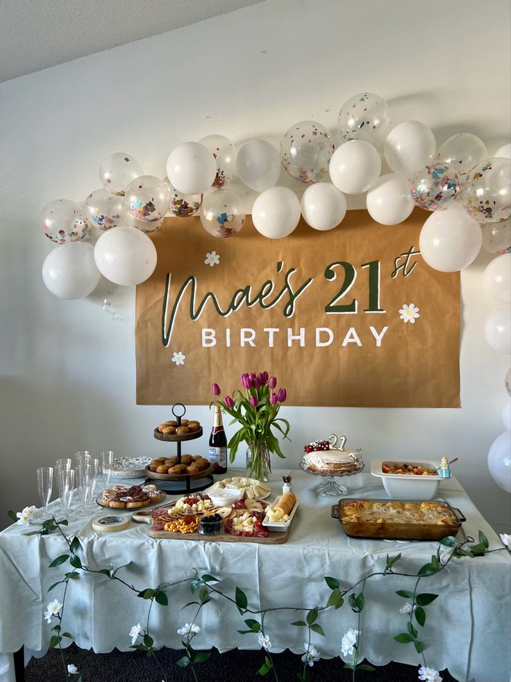 a table topped with lots of food and balloons