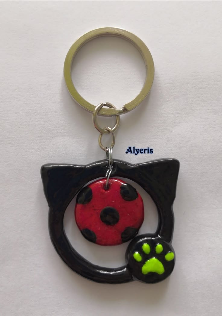 a keychain with a cat's paw and a ladybug on it