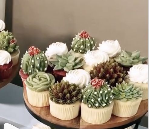 cupcakes decorated with succulents and flowers on a wooden platter