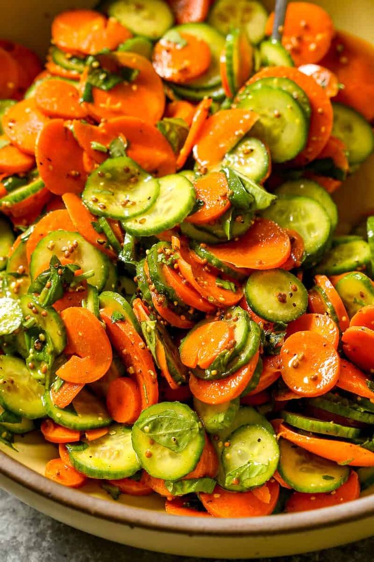 a bowl filled with sliced up carrots and cucumbers