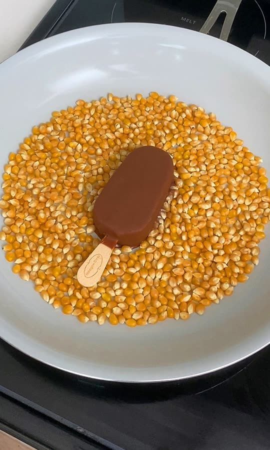 a white plate topped with corn and a scoop of ice cream on top of it