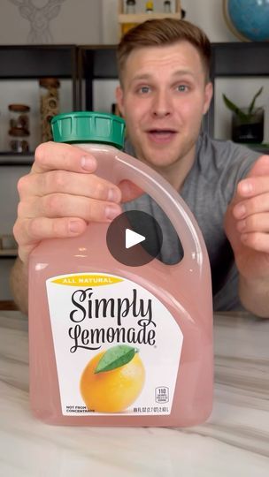 a man holding up a bottle of simply lemonade