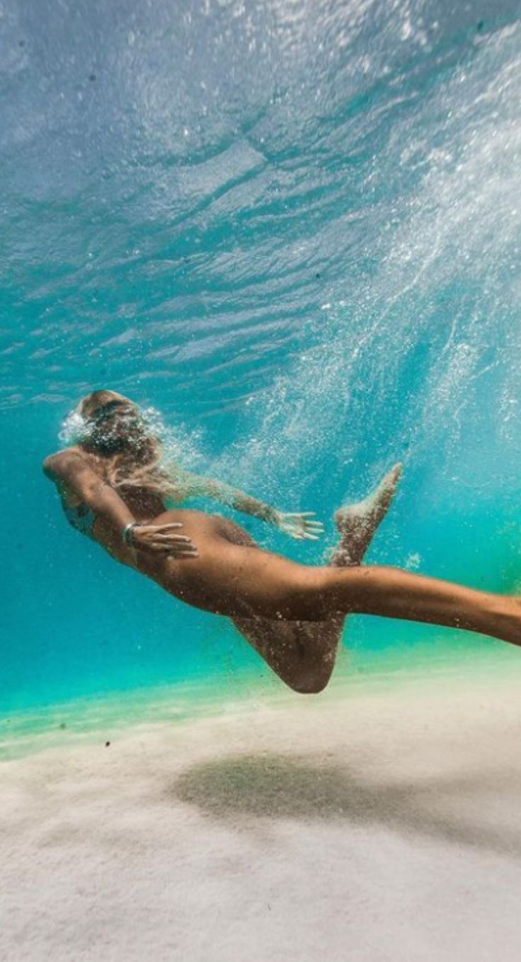 a woman is swimming under the water