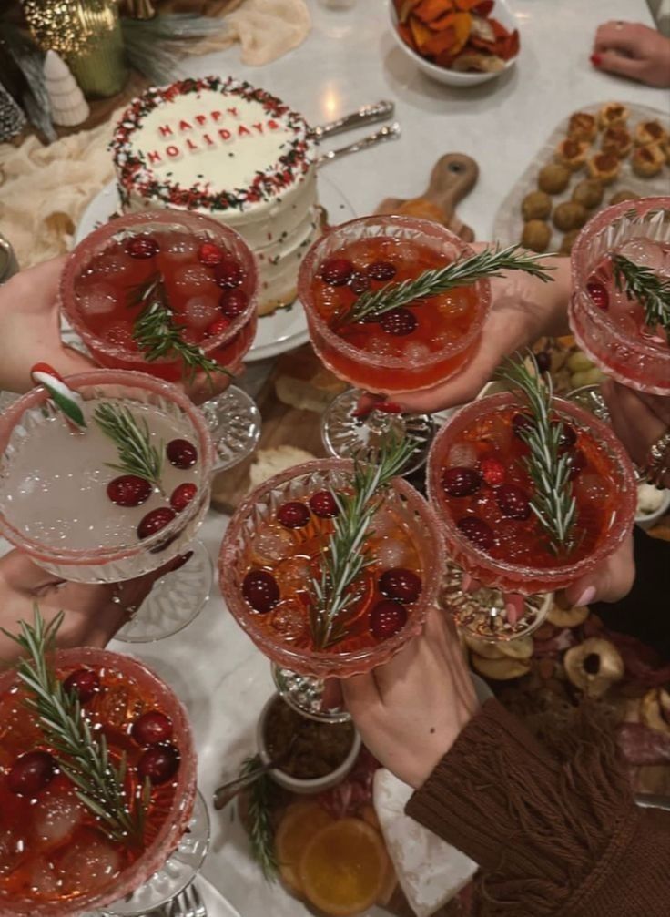 several people holding up glasses with drinks in them