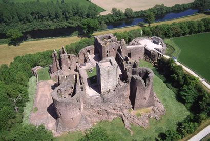 an aerial view of a castle in the middle of a field with trees and grass