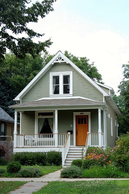 a gray house with white trim on the front porch