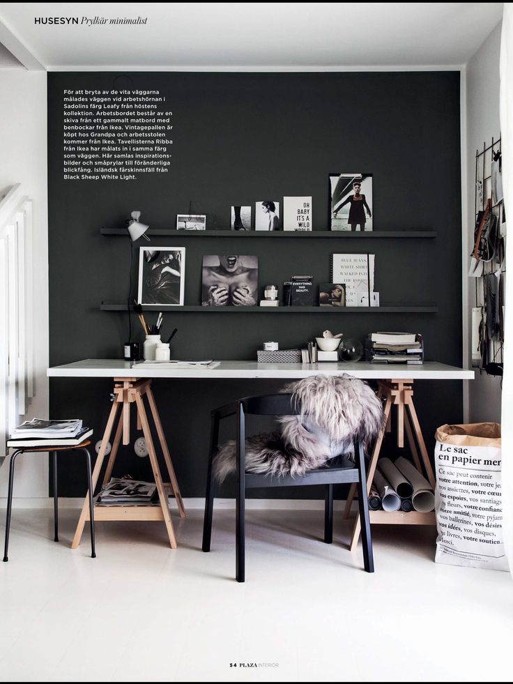 an office with black walls and white flooring, two desks on each side