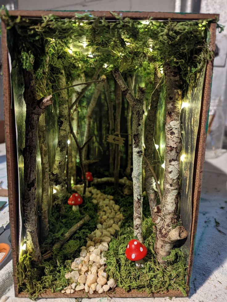 an open box with moss and mushrooms in the woods on display at a craft fair