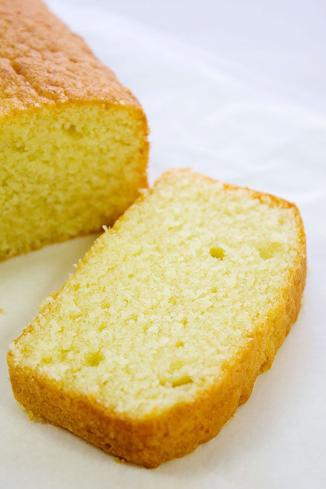 a loaf of bread sitting on top of a white tablecloth next to a slice of cake