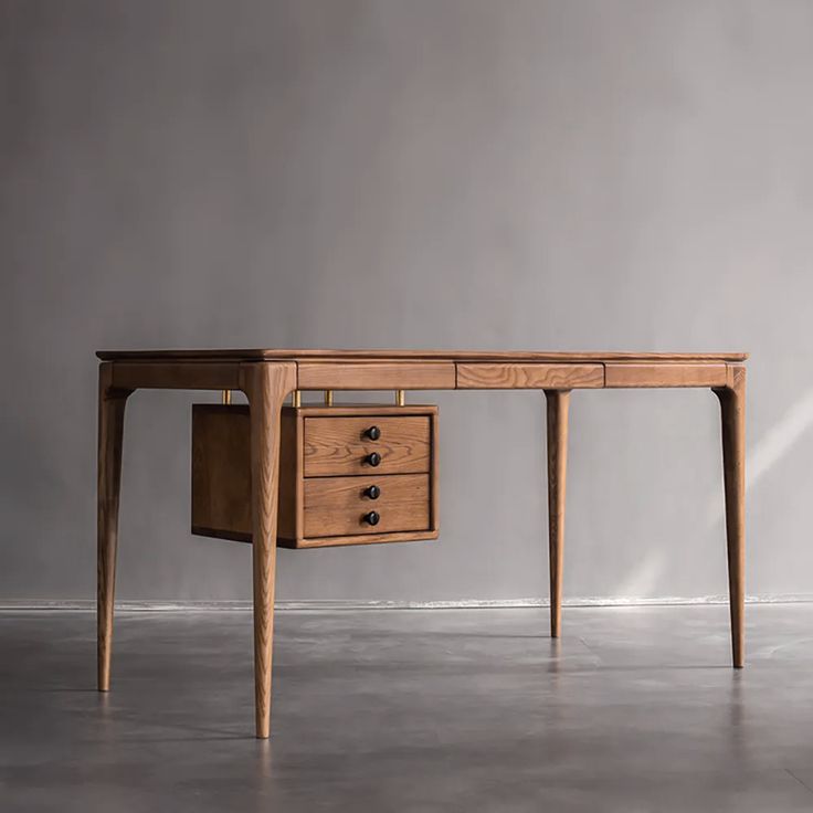 a wooden desk with two drawers sitting on top of concrete floor next to a wall