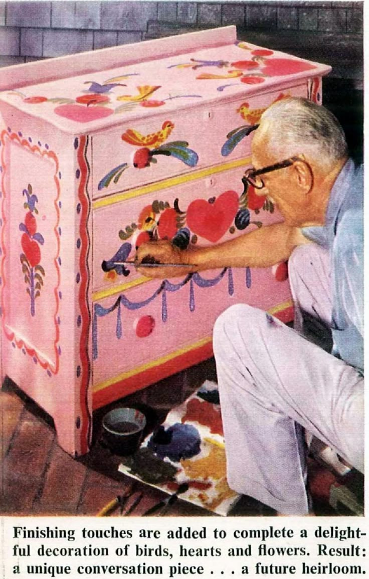 an old man painting a chest with hearts on it