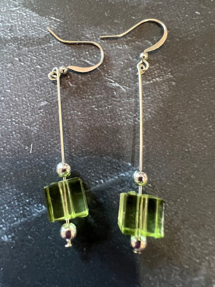 This light weight earring is simple but elegant. The vibe is a very light green. Silver beads accent this earring. Square Glass Beads Jewelry Ideas, Green Modern Sterling Silver Earrings, Modern Green Sterling Silver Earrings, Green Minimalist Pierced Earrings, Green Dangle Earrings For Formal Occasions, Minimalist Green Pierced Earrings, Green Linear Earrings For Parties, Green Long Drop Earrings, Formal Green Dangle Earrings