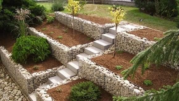 an outdoor garden with stone steps and plants in the center, surrounded by landscaping materials