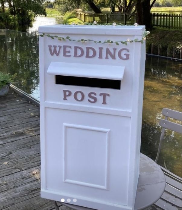 a white post box sitting on top of a wooden deck