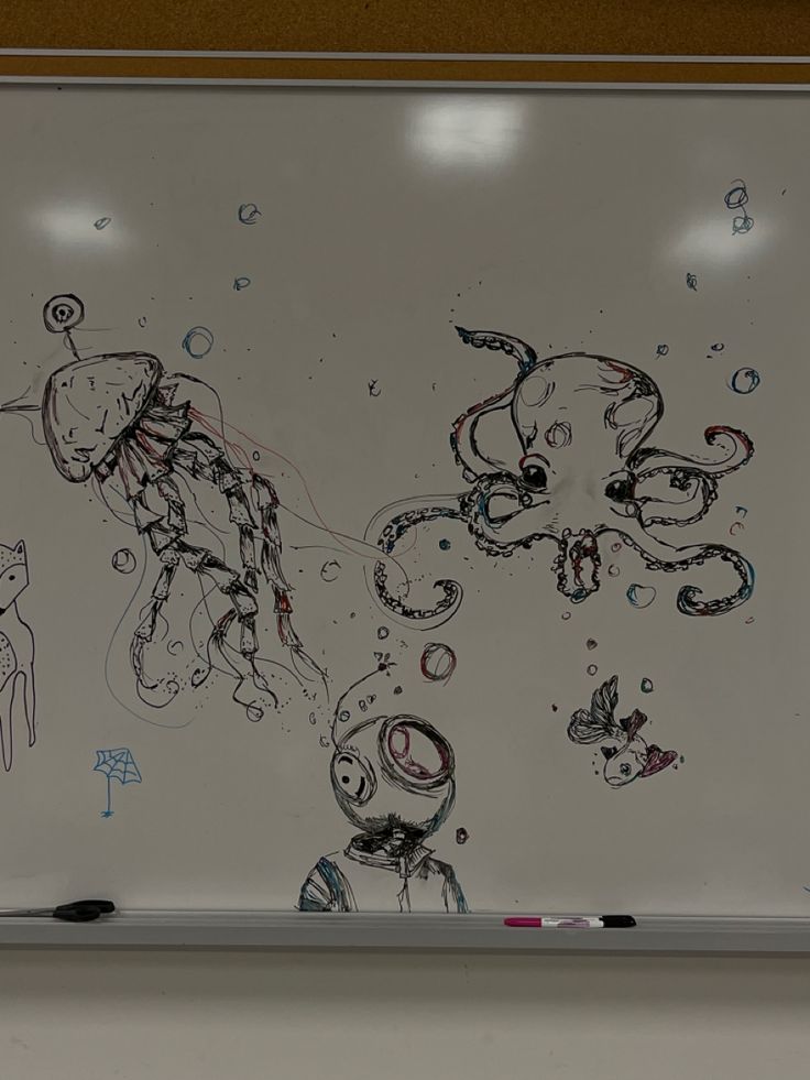 an art piece is hanging on the wall in front of a whiteboard with drawings