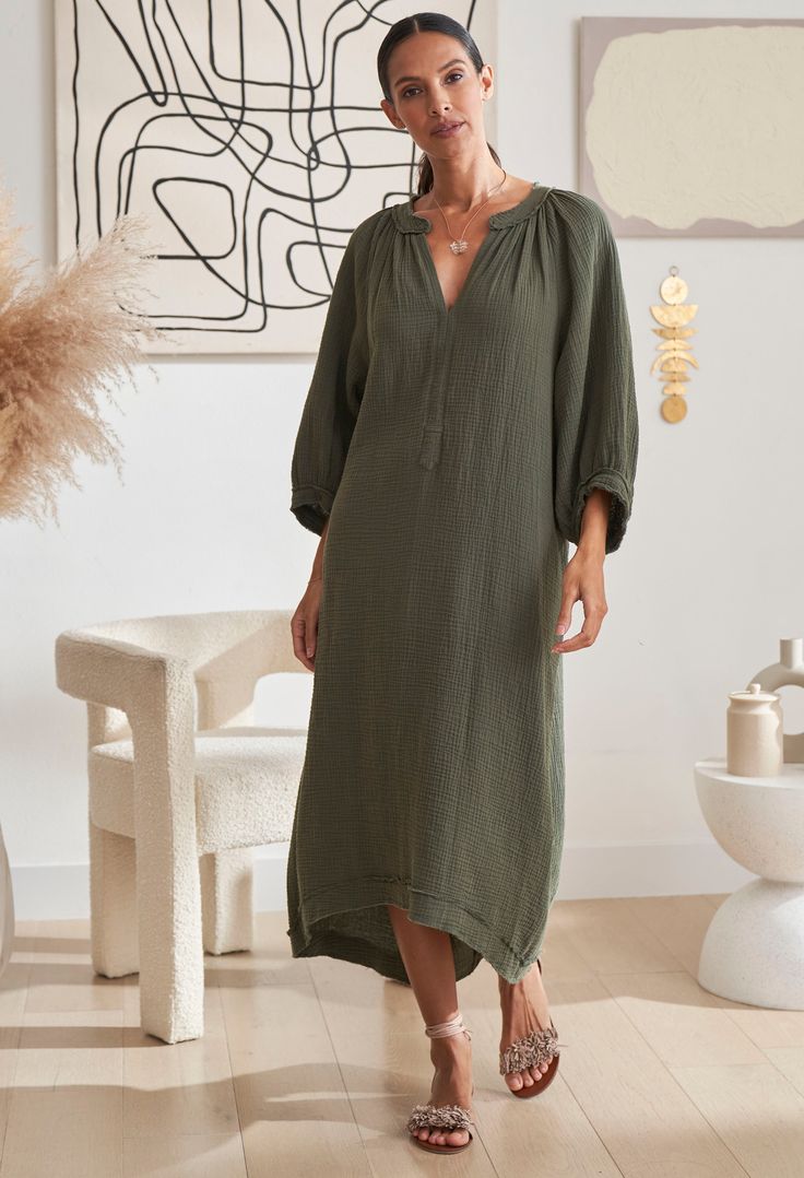 Woman walking wearing ocean+main Green Gauze Dress with Pockets Limited Edition Cotton Maxi Dress For Fall Beach, Cotton Maxi Dress For Fall Beach Outings, Cotton Maxi Dress For Beach In Fall, Daywear Relaxed Fit Tunic With Split Neck, Relaxed Fit Split Neck Tunic For Daywear, Cotton Maxi Dress With Relaxed Fit, Unlined, Relaxed Fit Cotton Maxi Dress Unlined, Fall Vacation Cotton Maxi Dress, Cotton Maxi Dress For Fall Vacation