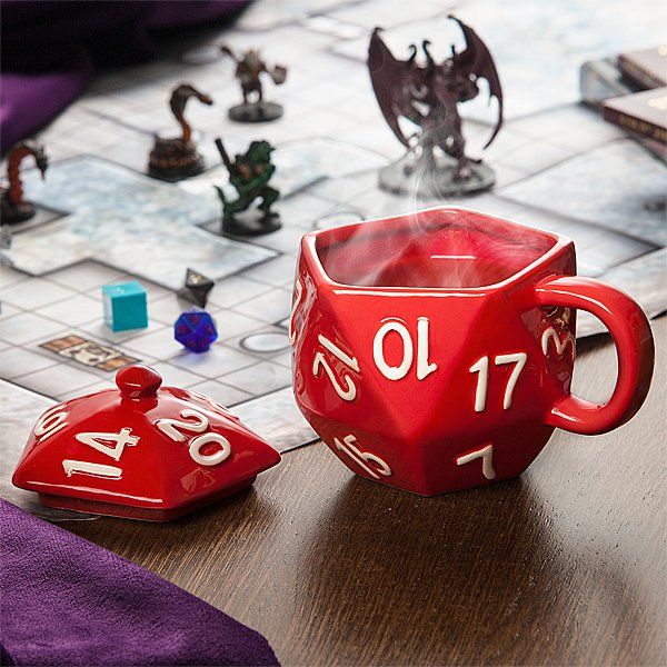 a red cup sitting on top of a wooden table next to a board game set