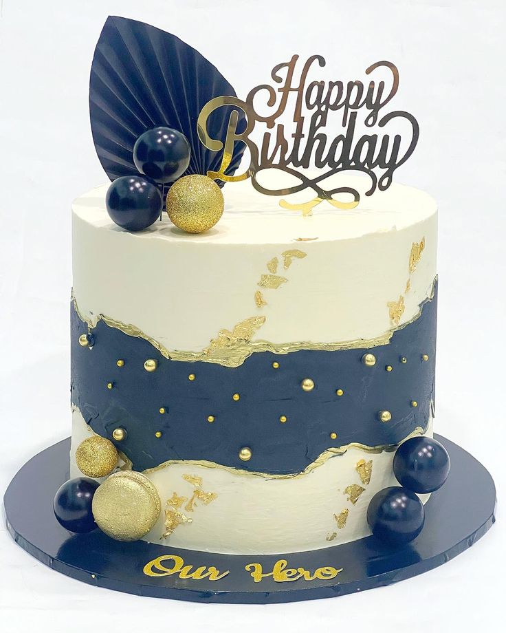 a white and blue birthday cake with gold decorations