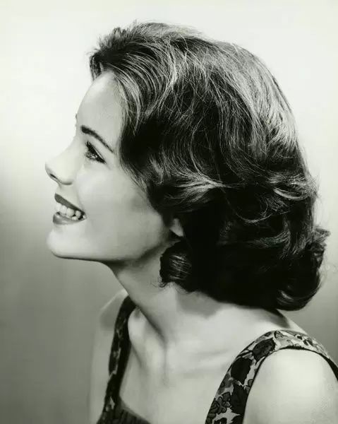 black and white photograph of a woman with her hair in a side - swept up style