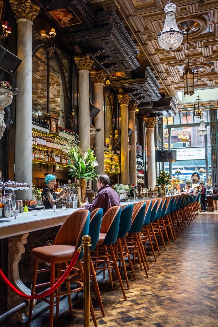 the bar is lined up with blue chairs