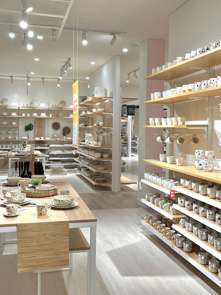 a store filled with lots of shelves covered in dishes and bowls on top of wooden tables