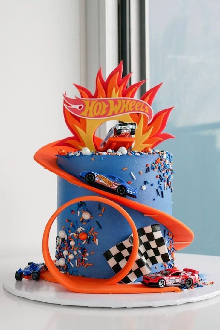 a birthday cake decorated with cars and flames